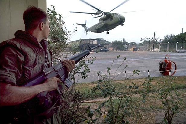 U.S. Marine provides security as American helicopters land at the DAO compound 1975